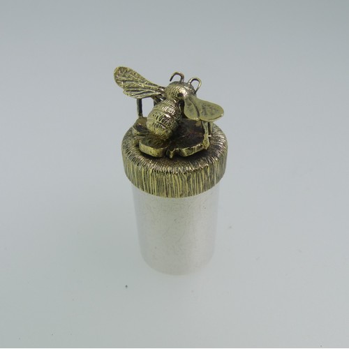Stuart Devlin; A miniature silver Pot, hallmarked London, 1981, of plain cylindrical form, the lift off gilt bark textured lid applied with a flower and bee, 3.5cm high, 14.5g.