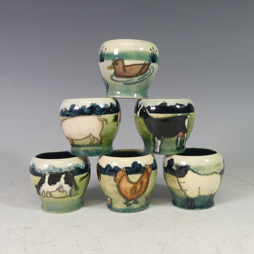 A set of six Moorcroft 'Farmyard' series Egg Cups, each with tube lined decoration on green ground, with factory marks to base, H 5cm, boxed (6)