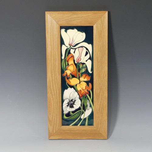 A Moorcroft 'Miss Alice' pattern framed Plaque, tube lined decoration on green ground, of second quality, designed by Emma Bossons, dated 2005, factory marks to base, frame 19cm x 40cm.