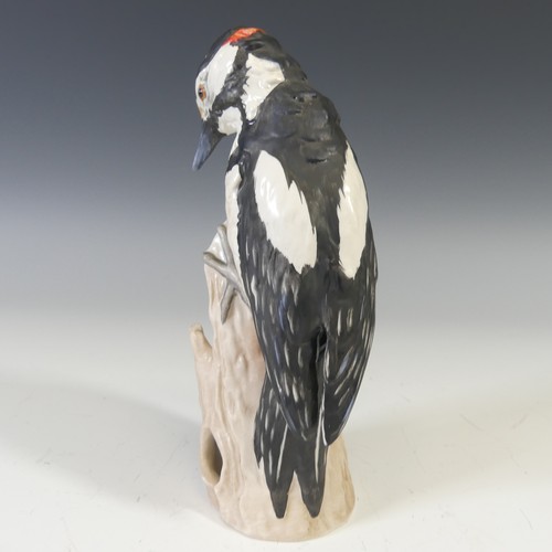 495 - A Goebel porcelain figure of a Parrot, modelled perched on a stump, factory marks to base, H 21cm, t... 