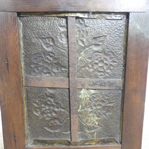 556 - An Arts & Crafts embossed brass and oak Fire Screen, in the manner of John Pearson, decorated wi... 