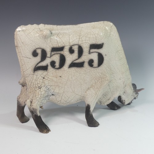 15 - Lawson E. Rudge (b. 1936), a raku fired studio pottery sculpture of a Grazing Cow, with crackle glaz... 