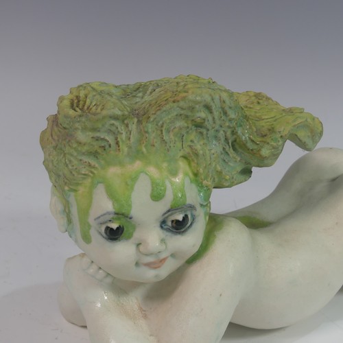 132 - Lawson E. Rudge (b. 1936), a raku fired studio pottery sculpture of a Baby, modelled laying on her s... 