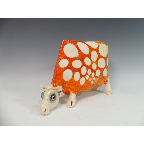 109 - Lawson E. Rudge (b. 1936), a studio pottery sculpture of a Grazing Cow, with orange glazed spot deco... 