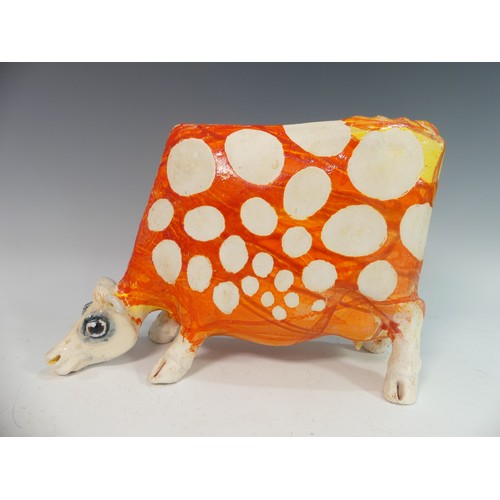 109 - Lawson E. Rudge (b. 1936), a studio pottery sculpture of a Grazing Cow, with orange glazed spot deco... 