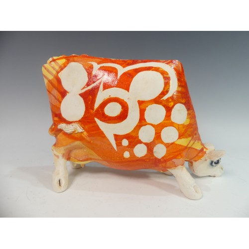 109 - Lawson E. Rudge (b. 1936), a studio pottery sculpture of a Grazing Cow, with orange glazed spot deco... 