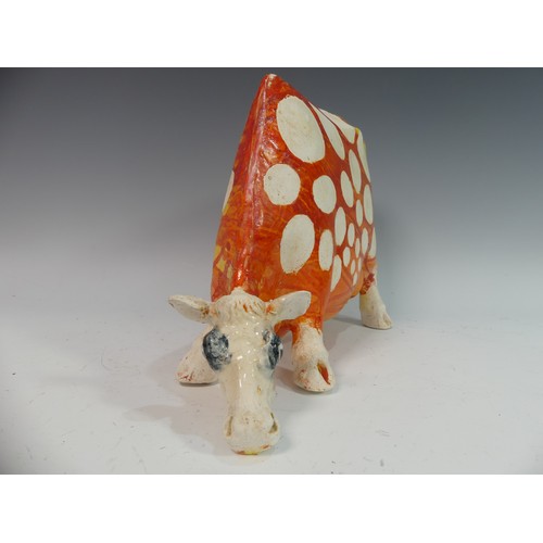 109 - Lawson E. Rudge (b. 1936), a studio pottery sculpture of a Grazing Cow, with orange glazed spot deco... 