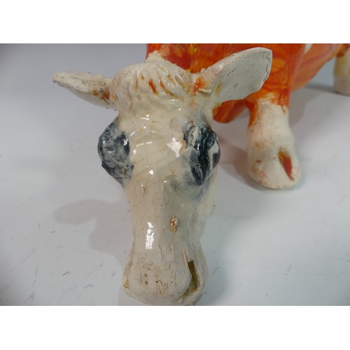 109 - Lawson E. Rudge (b. 1936), a studio pottery sculpture of a Grazing Cow, with orange glazed spot deco... 