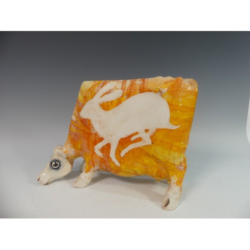 110 - Lawson E. Rudge (b. 1936), a studio pottery sculpture of a Grazing Cow, with orange glazed hare deco... 