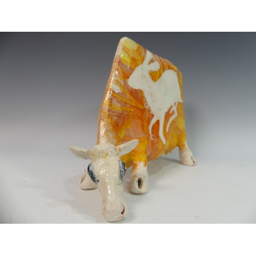 110 - Lawson E. Rudge (b. 1936), a studio pottery sculpture of a Grazing Cow, with orange glazed hare deco... 