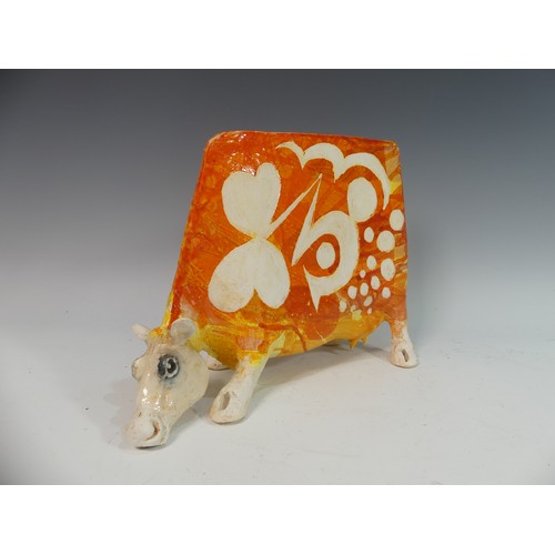 111 - Lawson E. Rudge (b. 1936), a studio pottery sculpture of a Grazing Cow, with orange glazed decoratio... 