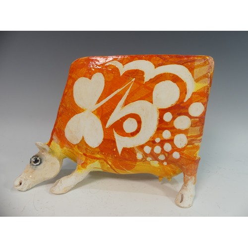 111 - Lawson E. Rudge (b. 1936), a studio pottery sculpture of a Grazing Cow, with orange glazed decoratio... 