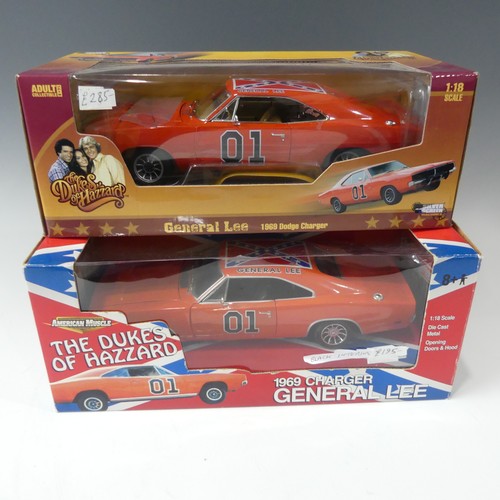 A boxed Dukes of Hazard General Lee 1969 charger, American Muscle, 1:18 scale diecast model with black interior together with a boxed silver screen machines 1:18 general Lee 1969 charger, both in super condition. (2)
