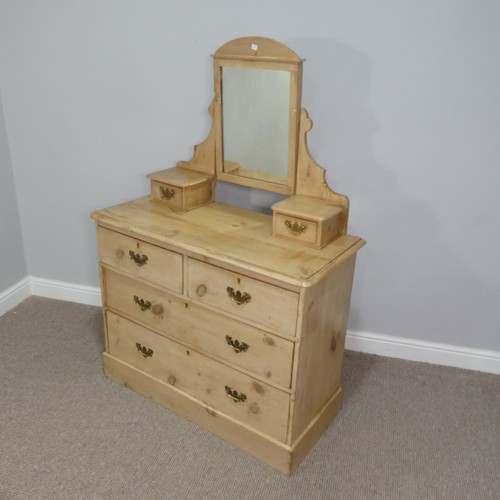 599 - A vintage pine Dressing Table, with shaped mirror flanked by two small drawers, on a base with three... 