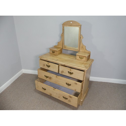 599 - A vintage pine Dressing Table, with shaped mirror flanked by two small drawers, on a base with three... 