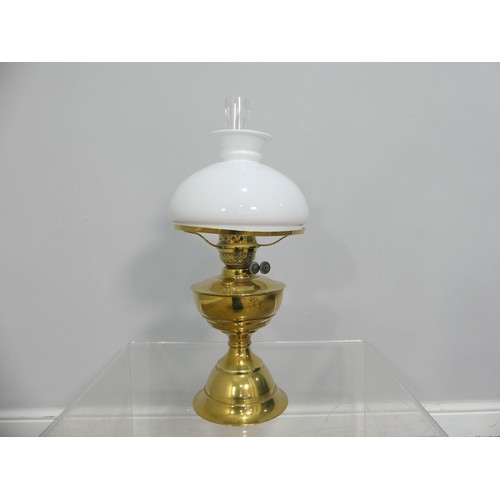 601 - A brass and frosted glass Oil Lamp, the shade with motifs, together with two others similar, tallest... 