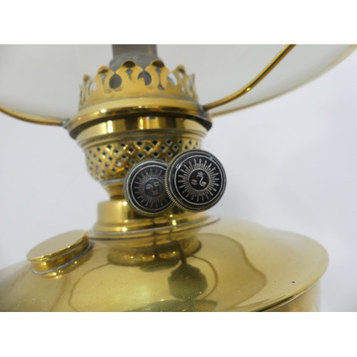 601 - A brass and frosted glass Oil Lamp, the shade with motifs, together with two others similar, tallest... 