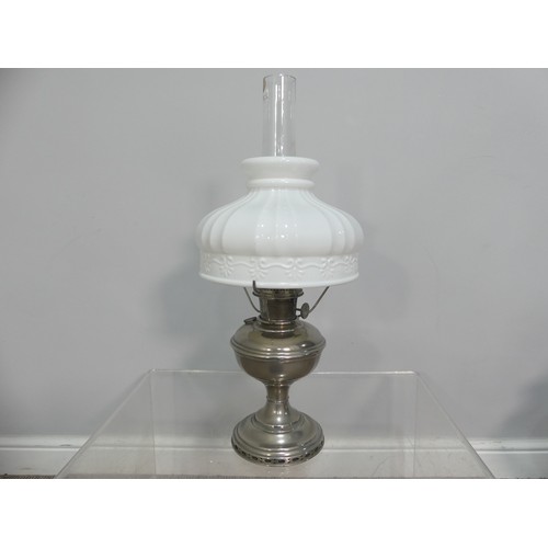 601 - A brass and frosted glass Oil Lamp, the shade with motifs, together with two others similar, tallest... 