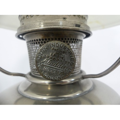 601 - A brass and frosted glass Oil Lamp, the shade with motifs, together with two others similar, tallest... 