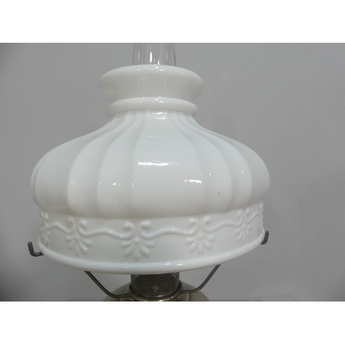 601 - A brass and frosted glass Oil Lamp, the shade with motifs, together with two others similar, tallest... 