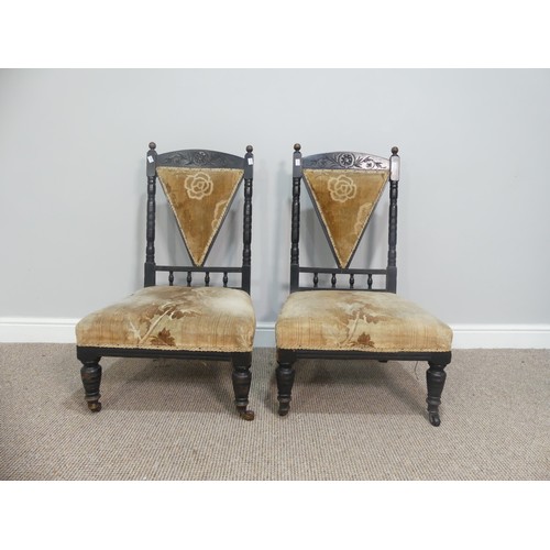 630 - A pair of Arts and Crafts ebonised Chairs, in the manner of Dresser, the carved back with turned spi... 