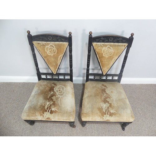 630 - A pair of Arts and Crafts ebonised Chairs, in the manner of Dresser, the carved back with turned spi... 