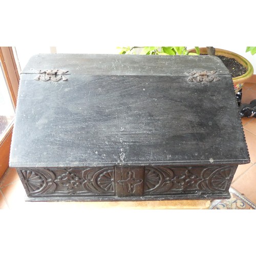 652 - An 18th century oak Bible Box, the sloped lid above a carved frieze, some scuffs, wear and damage to... 