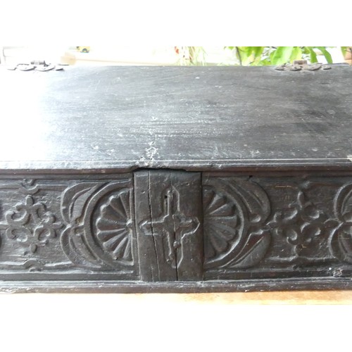 652 - An 18th century oak Bible Box, the sloped lid above a carved frieze, some scuffs, wear and damage to... 