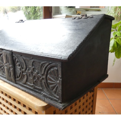 652 - An 18th century oak Bible Box, the sloped lid above a carved frieze, some scuffs, wear and damage to... 