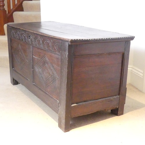 653 - An 18th century oak Coffer, the two-panel front with carved decoration, on square feet, with replace... 