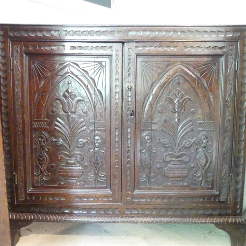 655 - An 18th century oak Corner Cupboard, the two-panel front with carved decoration, probably the bottom... 