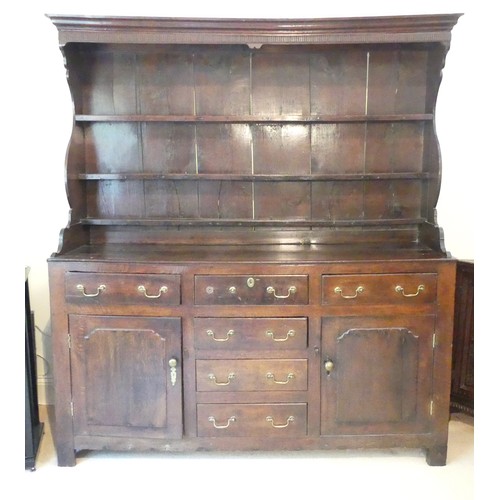 656 - A Georgian oak Dresser, having a three-tier plate rack above six drawers and two cupboards, one hand... 