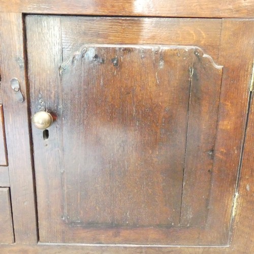 656 - A Georgian oak Dresser, having a three-tier plate rack above six drawers and two cupboards, one hand... 