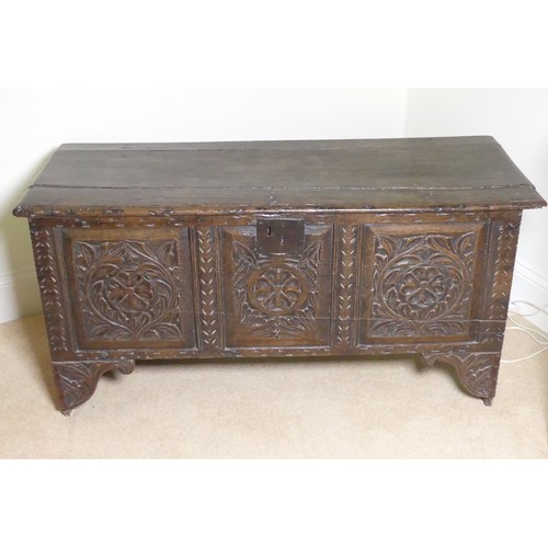 659 - An 18th century oak Coffer, with carved frieze and three carved panels, on stile feet, split to top ... 