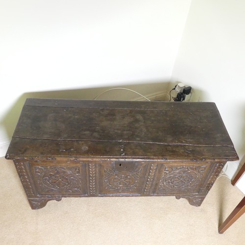 659 - An 18th century oak Coffer, with carved frieze and three carved panels, on stile feet, split to top ... 