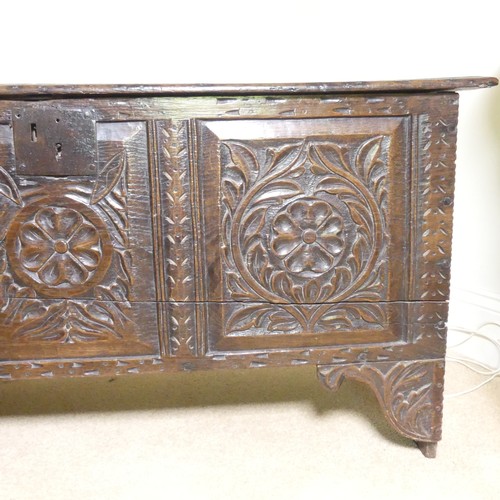 659 - An 18th century oak Coffer, with carved frieze and three carved panels, on stile feet, split to top ... 