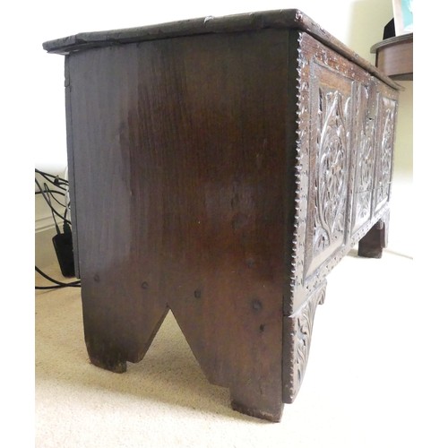 659 - An 18th century oak Coffer, with carved frieze and three carved panels, on stile feet, split to top ... 