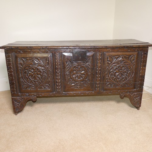 659 - An 18th century oak Coffer, with carved frieze and three carved panels, on stile feet, split to top ... 