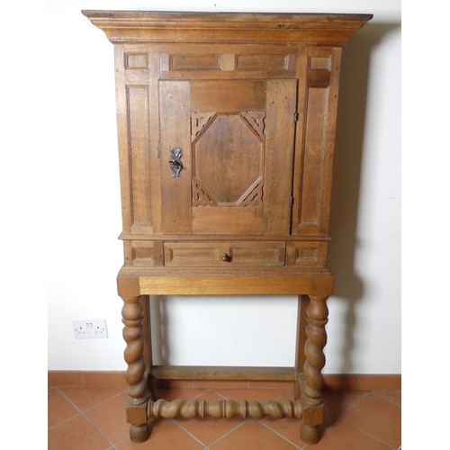 669 - A Victorian carved oak Cupboard, with central cupboard above a frieze drawer, raised on turned legs ... 