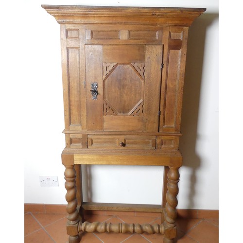 669 - A Victorian carved oak Cupboard, with central cupboard above a frieze drawer, raised on turned legs ... 