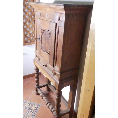 669 - A Victorian carved oak Cupboard, with central cupboard above a frieze drawer, raised on turned legs ... 