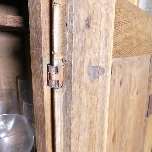 669 - A Victorian carved oak Cupboard, with central cupboard above a frieze drawer, raised on turned legs ... 