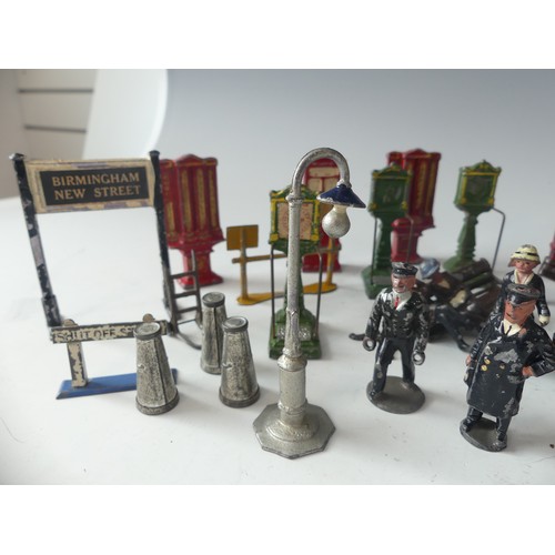 287 - A quantity of vintage '0' gauge lead station figures and accessories, including platform signs, vend... 