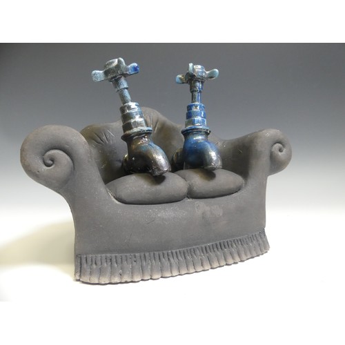 142 - Lawson E. Rudge (b. 1936), a studio pottery sculpture of Taps on a Sofa, one tap broken and repaired... 