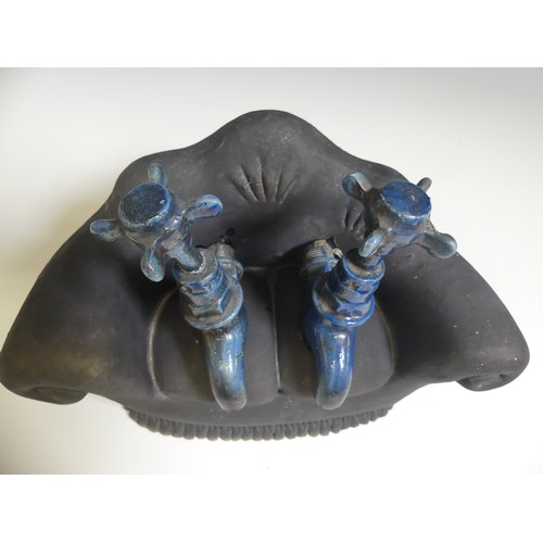 142 - Lawson E. Rudge (b. 1936), a studio pottery sculpture of Taps on a Sofa, one tap broken and repaired... 