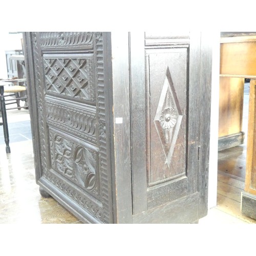 651 - An antique carved oak Cupboard, with heavily carved decoration, W 82cm x D 46cm x H 151cm.... 