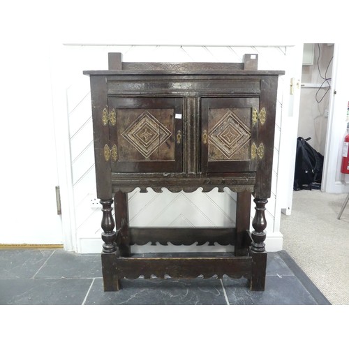 665 - A Victorian oak Cupboard, with a carved gallery back above carved cupboard doors, raised on turned l... 