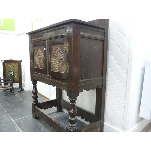 665 - A Victorian oak Cupboard, with a carved gallery back above carved cupboard doors, raised on turned l... 