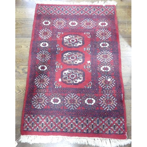 677 - Tribal Rugs; A small red ground wool pile Bokhara Rug, 134cm x 80cm.