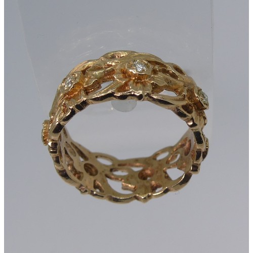 Stuart Devlin; 'The Welsh Gold Eternity Ring', with import marks for London, 1987, in 14ct gold of pierced foliate design set with seven diamonds, Size P½, approx total weight 6.6g, as commissioned by Franklin Mint, with box and paperwork.